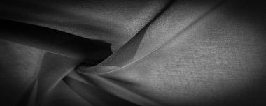 Koyu siyah şifon ipeği, bükülmüş iplik kullanımı nedeniyle hafif pürüzlü (matte, creped) yumuşak şeffaf bir kumaştır. Arkaplan dokusu