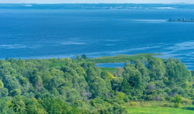 Yaz manzarası. Dünyanın Avrupa bölgesindeki bir nehir. Güneşli sıcak bir gün. Yeşil ağaçlar, çimenler. Mavi gökyüzü küçük bir bulut örtüsüyle.