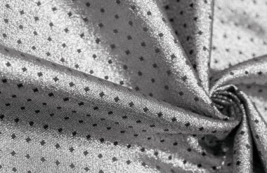 Küçük polka şeklinde metalik bir parıltıya sahip kumaş, siyah, soyut bir polikrom desen, uzay çağı estetiğine sahip siyah bir arkaplan karşısında parıldıyor ve bu kumaşa fütüristik bir gelecek hissi veriyor.