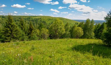 Yaz, tepe, tepeler, huş ağaçları dağların yamaçlarında büyürler. Yamaç boyunca dönen toprak bir yol, sıcak yaz günleri.