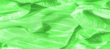 İpek kumaş. Yeşil kırışık kumaş dokusu. Yeşil buruşuk, dalgalı yüzey dokusu. Yakın çekim, yumuşak odaklanma. arkaplan, kalıp