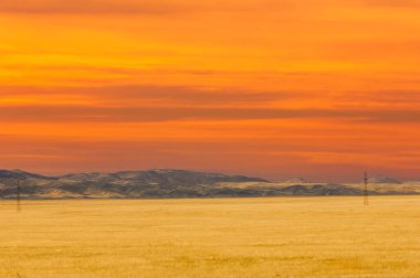 Steppe, bozkırda güneş ufuktan aşağı batarken gökyüzü parlak renklerle parıldıyor. Issız çölü bir gece daha izolasyonla baş başa bırakıyor. Hayatın gelgitlerinin ve akışlarının canlı bir hatırlatıcısı..