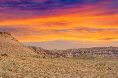 Çölde gün batımının büyülü güzelliğinin tadını çıkar. Parlak renklerin ve sakin atmosferin tadını çıkar. Kızıl Boguty Dağları arasında unutulmaz anları yakala.