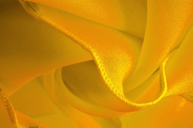 Dalgalı boruları olan sarı ipek organza. Kumaşın kenarındaki sınır. Soyut arkaplan. doku deseni. İpek organzanın narin bir açık dokuması vardır. Dalga arkaplanı. Boşluğu kopyala