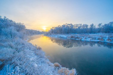 Kış günbatımının büyüleyici güzelliğinin tadını çıkar. Güneşin gökyüzünü canlı renklerle boyamasını izle. Doğanın mükemmelliğinin çarpıcı fotoğraflarını çek..