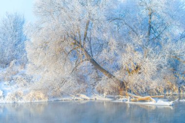 Güneş buzlu nehrin üzerinde batarken doğanın güzelliğinin tadını çıkar. Yanan turuncu ve pembe gökyüzünün nefes kesici manzarasına tanık olun. Kış büyüsünün sıcaklığını hisset..