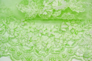 Açık yeşil dantelli, dokulu arka plan. Kartpostallar, posterler, dokular ya da duvar kağıtları için kullanılabilir. Eski dantel ve safir çizgileri olan soyut bir arka planı var..