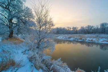 Buz Şafağı 'ndaki kış harikalar diyarının büyüsünü tecrübe et. Altın güneşin altındaki donmuş nehrin güzelliğinin tadını çıkar. Bu büyüleyici sahnede dünyanın tuhaf dönüşümüne tanık olun..
