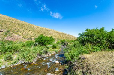 Doğanın dingin güzelliğinin tadını çıkar. Nehrin kayalık kanyonda nasıl zarifçe aktığına bakın. Kendini dağların kalbine daldır ve huzuru hisset..