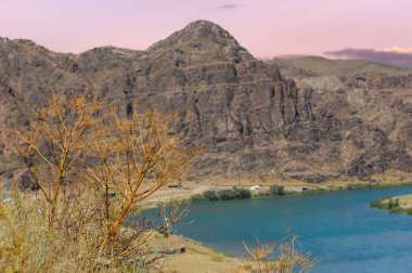Bozkırdaki nehirden gelen ferahlatıcı yaz suyunun tadını çıkar. Taşların arasından akan suyun rahatlatıcı sesinin tadını çıkar. Sakin ol ve sıcak günlerde nehir kenarında dinlen..