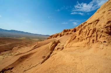 Gün batımında Boguty Kızıl Dağları 'nın nefes kesici güzelliğinin tadını çıkar. Huzur ve sükunet dolu bir dünyaya dalın. Kum ve gökyüzünün çarpıştığı nefes kesen renk dansına tanık olun..