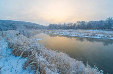 Şafakta donmuş bir nehrin cazibesini hissedin. Kendini tuhaf bir kış harikalar diyarına daldır. Şafağın altın renklerine kapıl.
