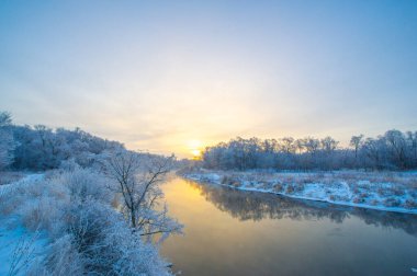 Kış günbatımının büyüleyici güzelliğinin tadını çıkar. Güneşin gökyüzünü canlı renklerle boyamasını izle. Doğanın mükemmelliğinin çarpıcı fotoğraflarını çek..