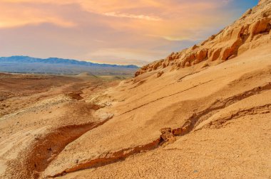 Boguty Kızıl Dağları 'nın huzurlu güzelliğinin tadını çıkar. Güneşin batışını ve renklerin gökyüzünü büyüleyici bir manzarayla boyamasını izleyin. Kendini manzaraya daldır.