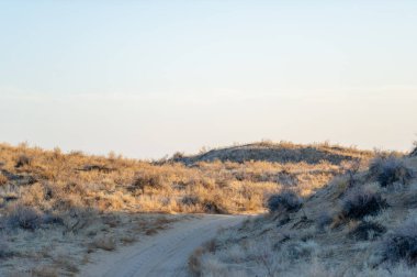 Bozkırdaki sonbaharın güzelliğinin tadını çıkar. Kumulların üzerinden güneşin batışını izle. Manzara boyunca altın renkler sergiliyor. Gün batımında havadaki dinginliği ve sihri hisset..