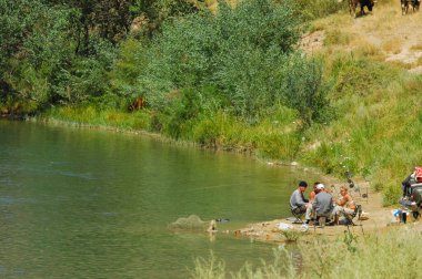 Huzurlu bir nehrin üzerinde günbatımının sakinliği. Görkemli dağların ve dingin bir ortamda yemyeşil ağaçların güzelliğinin tadını çıkar. Kendinizi bu manzaranın doğal güzelliğine daldırın..