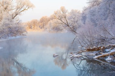 Kış doğasının etkileyici güzelliğinin tadını çıkar. Güneşin batışını ve gökyüzünü canlı renklerle renklendirmesini izleyin. Ilık parıltının donmuş nehri nasıl yansıttığına bak. Sihirli bir sahne yaratmak