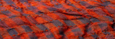 Doku arka planı, desen. Bir insanın boynuna takılacak yün bir eşarp. Atkıda kahverengi kırmızı siyah renk