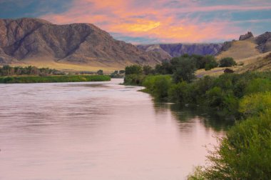 Çarpıcı uçurumların ve dolambaçlı çayır nehrinin tadını çıkar. Vahşi doğada gün batımının dramatik renklerine tanık olun. Bozulmamış doğal manzaraların vahşi güzelliğine dalın..