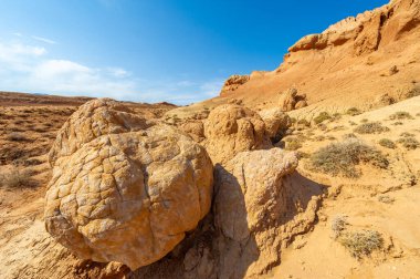 Red Boguty Dağları 'nın arkasındaki gün batımının nefes kesici güzelliğinin tadını çıkar. Kendini doğanın ateşli başyapıtının dinginliğine ve sükunetine bırak. Çöldeki rüyalara tanık ol..