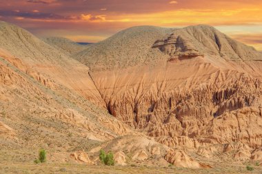 Gün batımında Red Bogut Dağları 'nın muhteşem güzelliğinin tadını çıkarın. Doğanın ilahi büyüsünün cazibesini hisset. Doğa severler ve fotoğrafçılar için pitoresk bir yer..