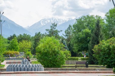 Huzur ve Majesteleri: Uzun ağaçlar ve görkemli dağlarla çevrili bu manzaralı yolda seyahat edin. Doğanın dinginliği duyularınızı kucaklasın ve ruhunuza ilham versin. 2021 06 10 Kazakistan Almatı