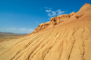 Red Boguty Dağları 'nın arkasındaki gün batımının nefes kesici güzelliğinin tadını çıkar. Kendini doğanın ateşli başyapıtının dinginliğine ve sükunetine bırak. Çöldeki rüyalara tanık ol..