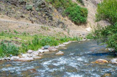 Dağ kanyonundaki doğal güzelliğin tadını çıkar. Nehrin kayalık arazide huzurlu akışını hisset. Temiz dağ havasını içine çek ve görkemli manzaranın tadını çıkar..