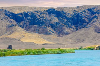 Tüm ihtişamıyla doğanın güzelliğinin tadını çıkar. Sakin nehrin üzerinde güneşin batışını izle. Görkemli dağların ve yemyeşil ağaçların tadını çıkar..