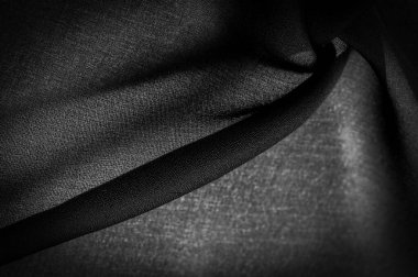 Koyu siyah şifon ipeği, bükülmüş iplik kullanımı nedeniyle hafif pürüzlü (matte, creped) yumuşak şeffaf bir kumaştır. Arkaplan dokusu