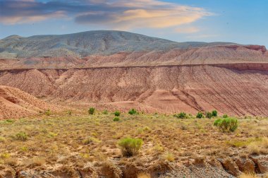 Boguty 'nin Kızıl Dağları. Doğanın şaheserinin güzelliğini tecrübe edin. Görkemli dağların üzerinde büyüleyici günbatımına kapıl. Parlak renkler sende bir merak uyandırsın..