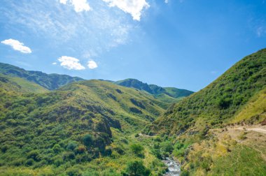 Dağların ortasındaki nehrin dingin akışını hisset. Çevrenizdeki doğanın çarpıcı güzelliğinden büyülenin. Kayalık manzaraya bakarken huzur ve sükuneti hissedin.