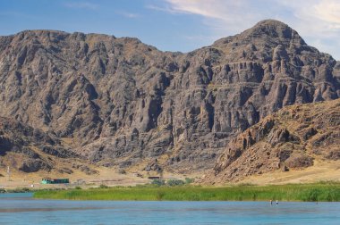 Kayalarla çevrili nehrin resimli görüntüsü. Doğa sükunet ve güzelliğe ilham verir. Kaya oluşumları sakin ve resim gibi bir ortam yaratıyor..