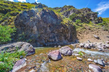 Nehrin dingin akışını kayalık kanyonda hisset. Dağların doğal güzelliklerine dalın. Doğanın harikalarıyla bağlantı kurarken huzur ve sükunet duygusu hissedin..