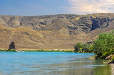 Sakin nehrin üzerinde günbatımının dinginliğinin tadını çıkar. Görkemli dağların ve yemyeşil ağaçların güzelliğinin tadını çıkar. Doğayla bağlantı kur ve bu mutlu ortamda huzur bul..