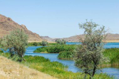 Doğanın dingin güzelliğinin tadını çıkar. Güneşin resimli manzaranın üzerinden batışını izle. Dağların, ağaçların ve dolambaçlı nehrin nefes kesici manzarasının tadını çıkar..