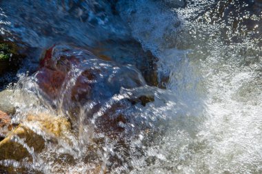 Kayalık engellerden akan sakin sular doğanın dayanıklılığının uyumlu bir senfonisini yaratır. Hareket halindeki Doğa