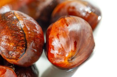 El değmemiş beyaz arka planda kestanelerin nefes kesen görüntüsü. Sonbaharın özünü en saf haliyle yakalar. Mevsimin güzelliklerini aktarmak için ideal.