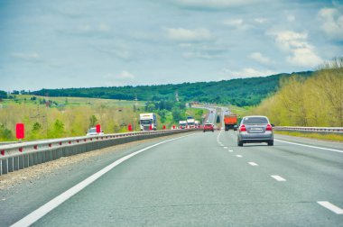Doğada manzaralı bir yolculuğun tadını çıkar. Otoyol boyunca uzanan görkemli ağaçların güzelliğinin tadını çıkar. Rahat bir araba yolculuğunun huzur ve sükunetini yaşayın..