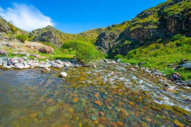 heybetli kayalık bir kanyondan akan bir nehrin dinginliği. Dağların ve nehrin doğal güzelliği. Doğanın hayranlık uyandıran gücünü ve zarafetini tecrübe edin. Bu manzaralı harikayı gördüğünüz gibi..