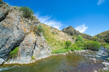 Nehir boyunca doğanın huzurlu güzelliğinin tadını çıkar. Etrafı görkemli dağlarla çevrili kayalık bir kanyonda dolaş. Nehrin huzurlu akışına kapıl.