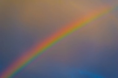 Karanlık bir gökyüzünde gökkuşağı. Karanlık bir arkaplanda güzel zıt renkler. Büyüleyici ışık ve doğanın renkleri. Karanlık zamanlarda bile umut ve güzelliğin sembolü..