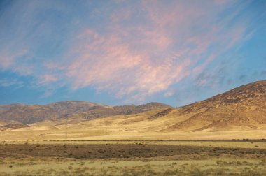 Steppe, Prairie, sade, pampa. Batan güneşin parlayan sıcaklığıyla kucaklanan çayır, bir başka günün hüzünlü öyküsünü fısıldıyor. Günbatımı Yansımaları