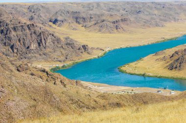 Nehrin güzelliğini ve huzurunu keşfedin. Kristal berrak mavi suda yüzmek. Nehir kıyısındaki kayalıklarda rahatla.