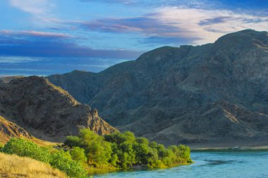 Orta Asya 'da günbatımının tadını çıkar. Bozkırdaki kayaların arasında nehir kenarında rahatla. Huzurlu bir ortamda doğayı tecrübe etmek..