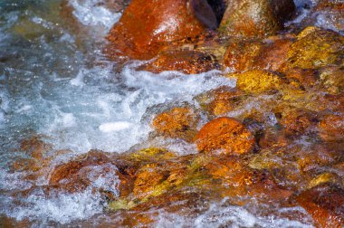 Doğadaki akan suyun güzelliğini yakala. Fotoğrafçılık doğal manzaraların uyumu ve sükunetini gösteriyor. Düz taşların karmaşık detaylarını yakalamaya odaklan.