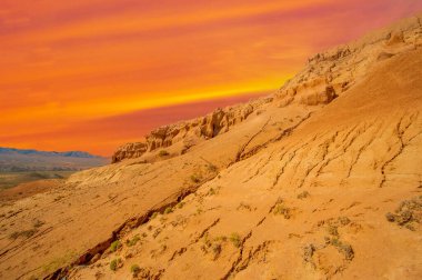 Red Boguty Dağları 'nın arkasında nefes kesici bir günbatımının tadını çıkar. Çölde doğanın ateşli başyapıtına tanık olun. Büyüleyici doğal manzaralarda rüya gibi bir maceraya atılmak..