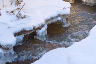 Nehir kışın donar. Ormandaki en sevdiğim kış nehri sessizliği büyüleyiciydi. Sadece rüzgarın sesi ve akan akarsu yüzünden kırılmıştı. Hala hayatta, suyun altında. kar ve buz