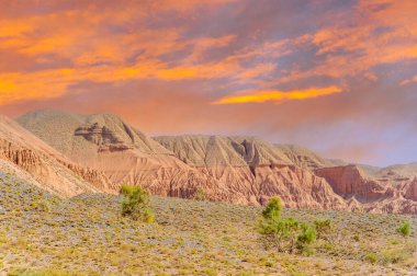 Güneş ufkun altına batarken Kırmızı Boguty Dağları efsanevi bir cennete dönüşür. Kendinizi büyüleyici renklere daldırın. Dağ alacakaranlık çöl rüyalarının sıcacık kucağında güneşlenirken.