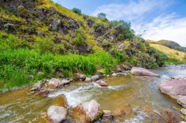Görkemli bir kanyonda akan bir nehrin sükunetini hissedin. Doğayla bağlantı kurun ve çarpıcı dağ manzarasına hayran olun. Doğal manzaranın güzelliğine ve dinginliğine dalın..